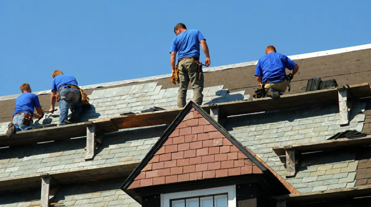 Roof replacement in progress with a team of professional contractors installing new shingles on a residential home in Oakland, CA